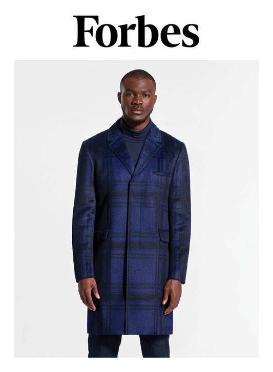 Image features the Forbes logo and an image of a male model wearing the Sentaler Technical Suri Alpaca Notched Lapel Overcoat featured in Technical Suri Alpaca and available in Navy Plaid Blue. Seen from front above the knees.