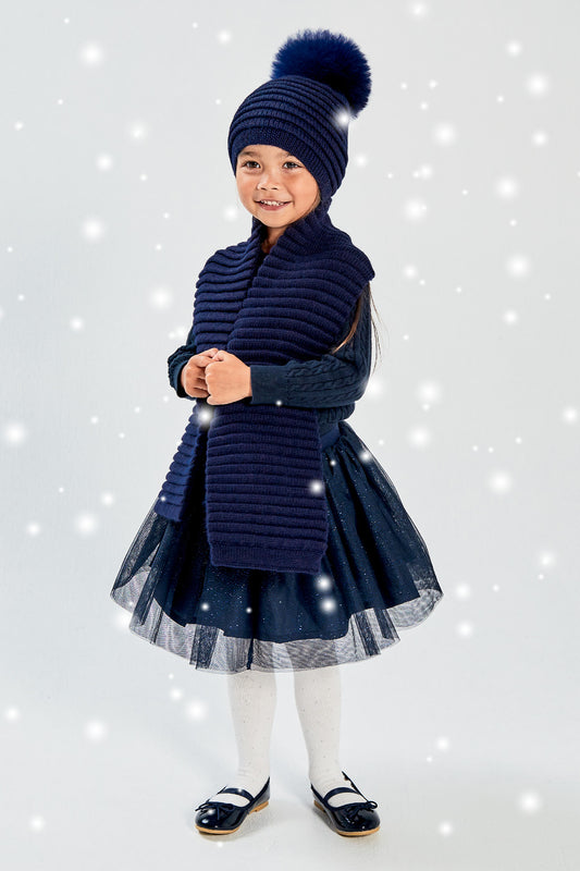 Sentaler Kids (1-5 Years) Ribbed Hat with Oversized Fur Pompon and Ribbed Scarf featured in Baby Alpaca and available in Navy. Seen from front with snow effect.