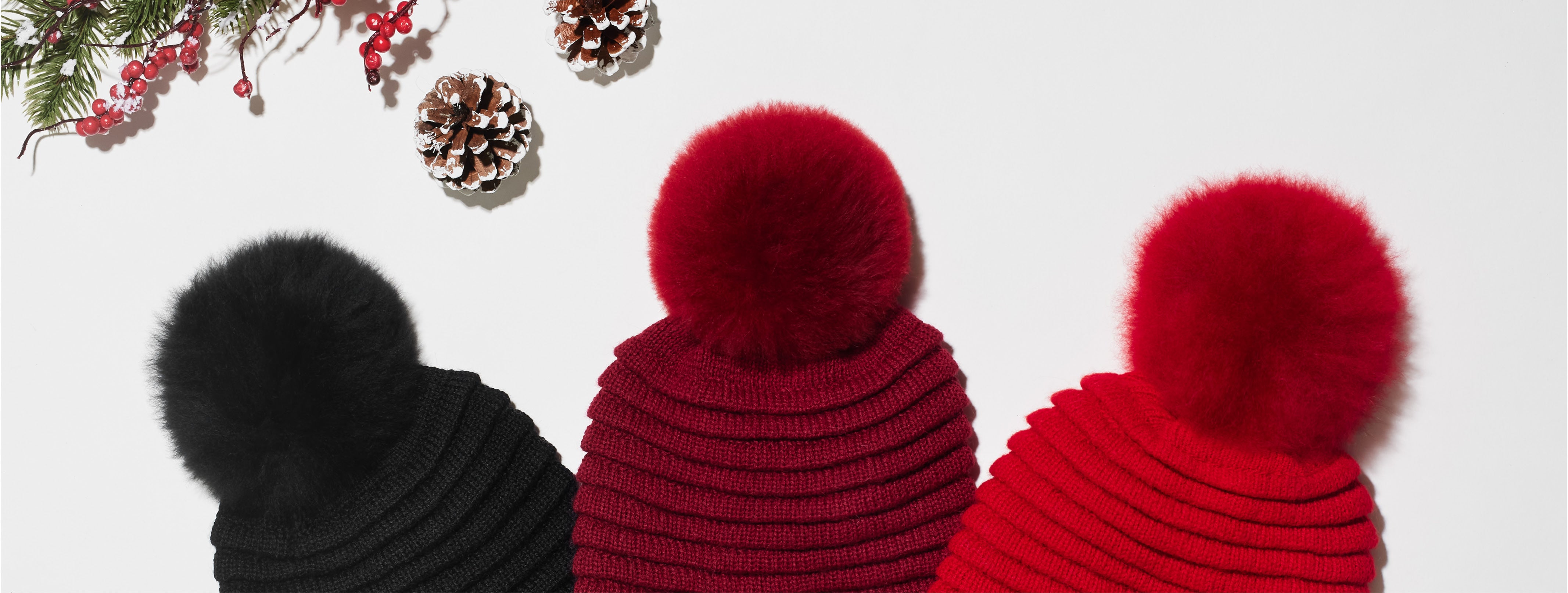Sentaler 2021 Gift Guide featuring Close Up of Women's Ribbed Hat with Oversized Fur Pompon in Black, Garnet Red and Scarlet Red.