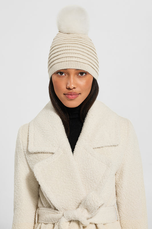 Sentaler Adult Ribbed Hat With Oversized Fur Pompon featured in Baby Alpaca and available in Ivory. Seen from front above the waist on model.
