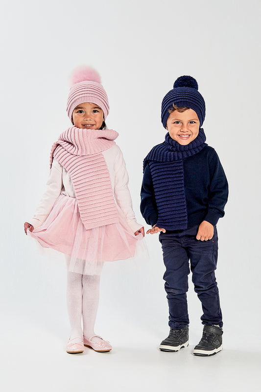 Sentaler Kids (1-5 Years) Ribbed Hat with Oversized Fur Pompon and Ribbed Scarf featured in Baby Alpaca and available in Pink. Seen from front on model.